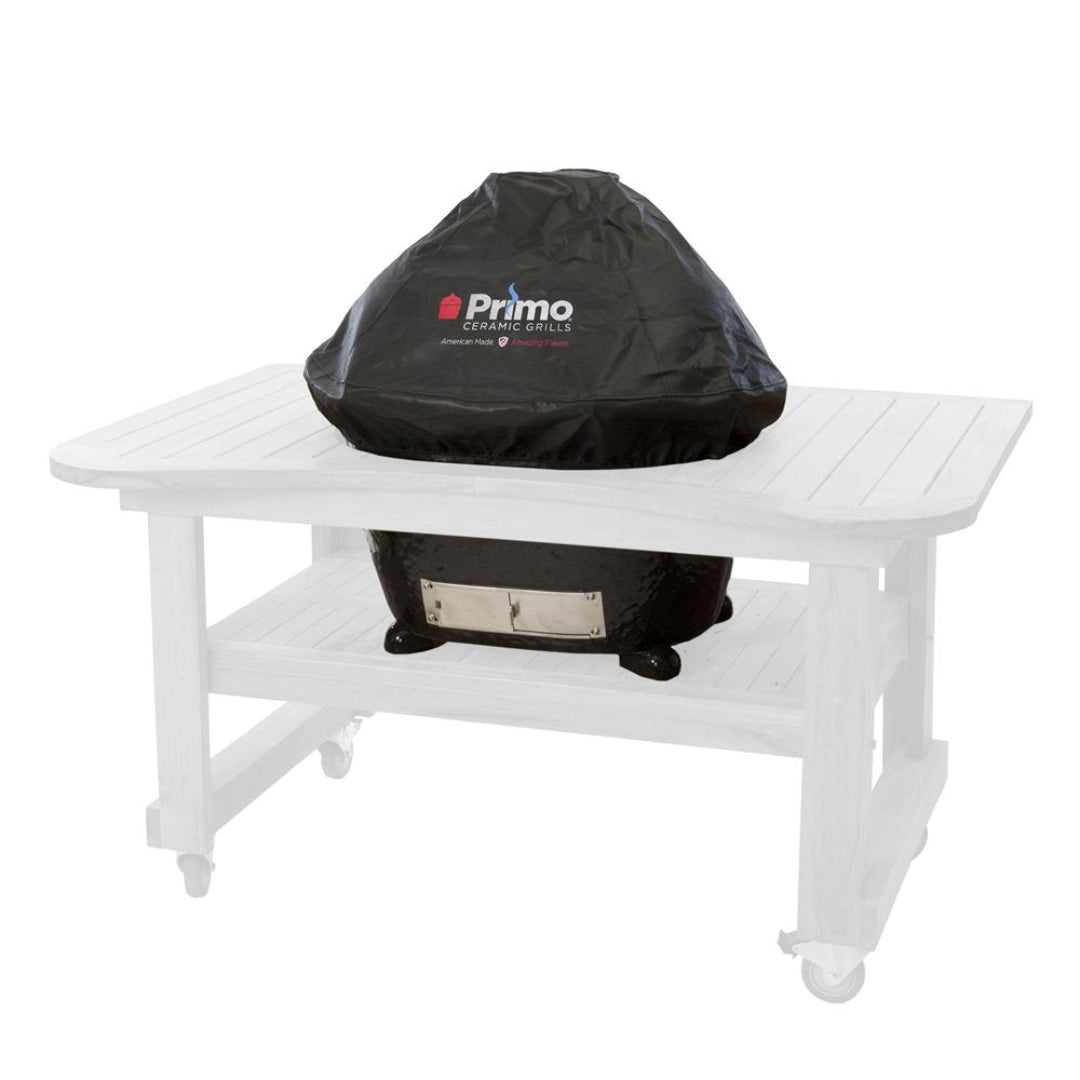 Primo ceramic kamado grill black fitted protective cover with Primo logo over ceramic kamado set in wooden outdoor prep table cart