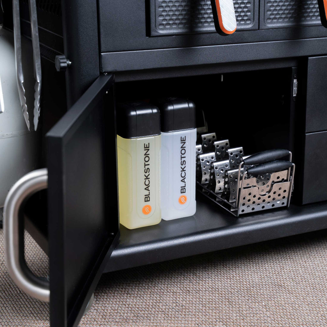 Blackstone 36-inch Patio 4-Burner Air Fryer Combo outdoor gas grill lower cabinet with Blackstone oil squeeze bottles and stainless steel air fryer/grill accessory baskets