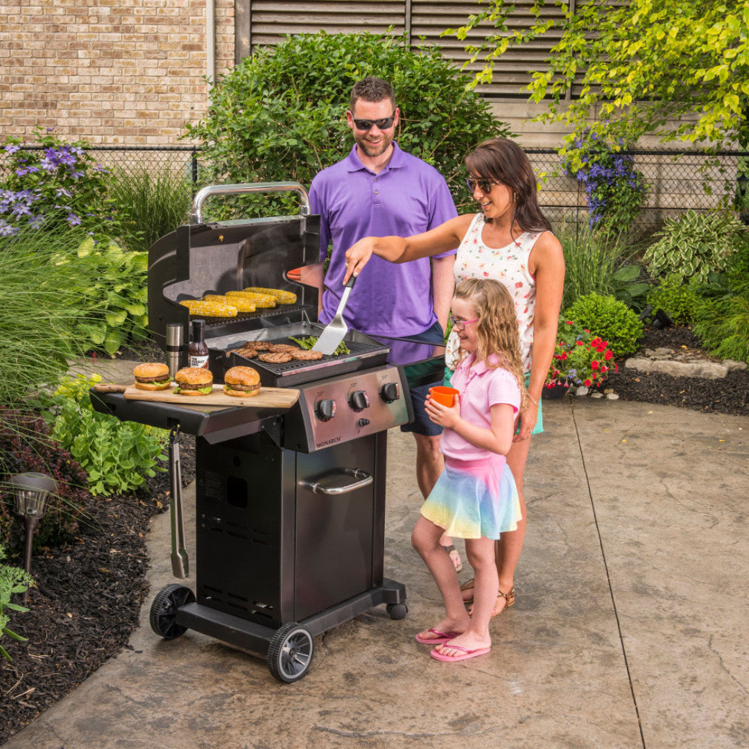 Family grilling, Broil King, outdoor cookout, 3-burner grill with burgers and corn, patio scene