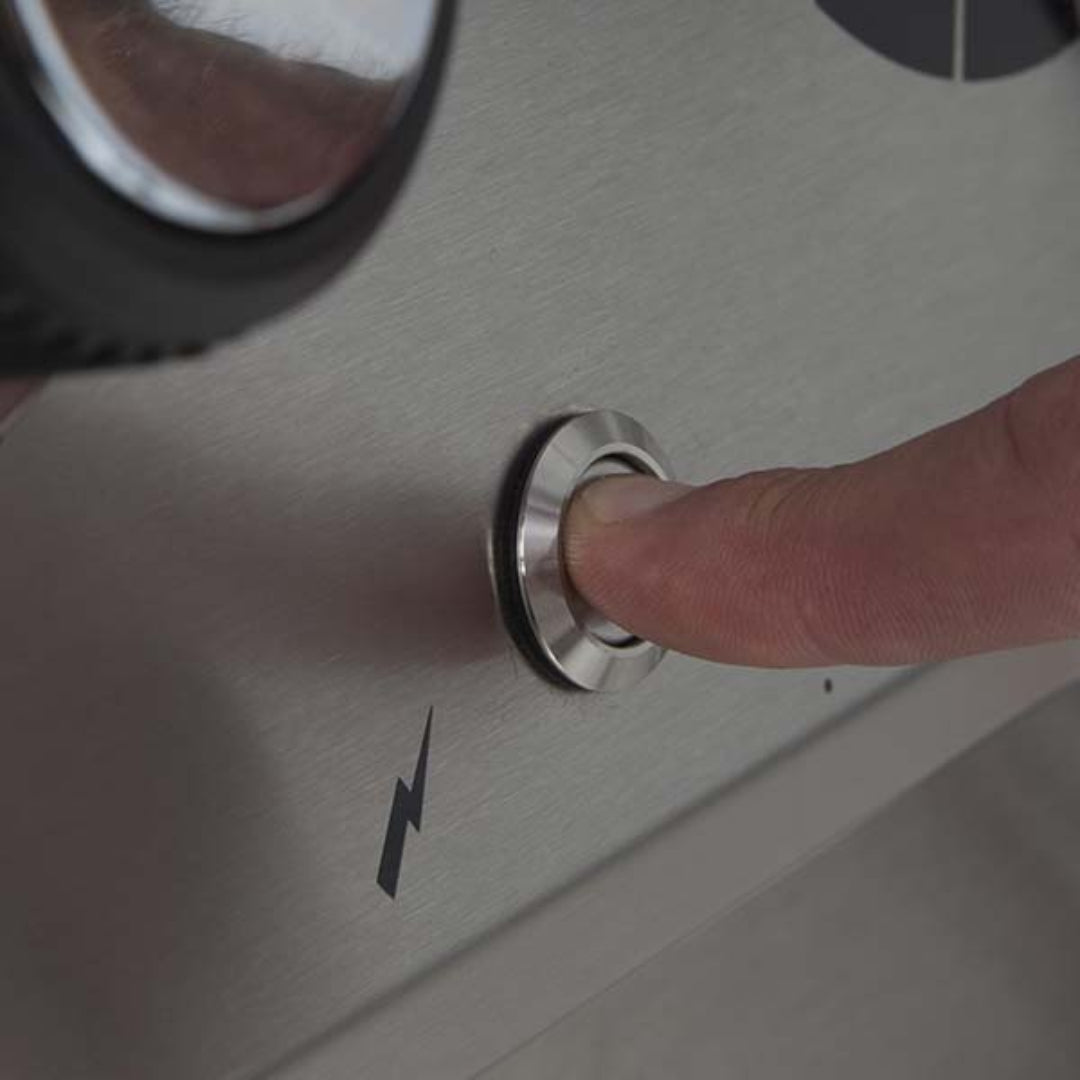 Ignition button close-up, Broil King Crown series, stainless steel push-button igniter, outdoor gas grill detail