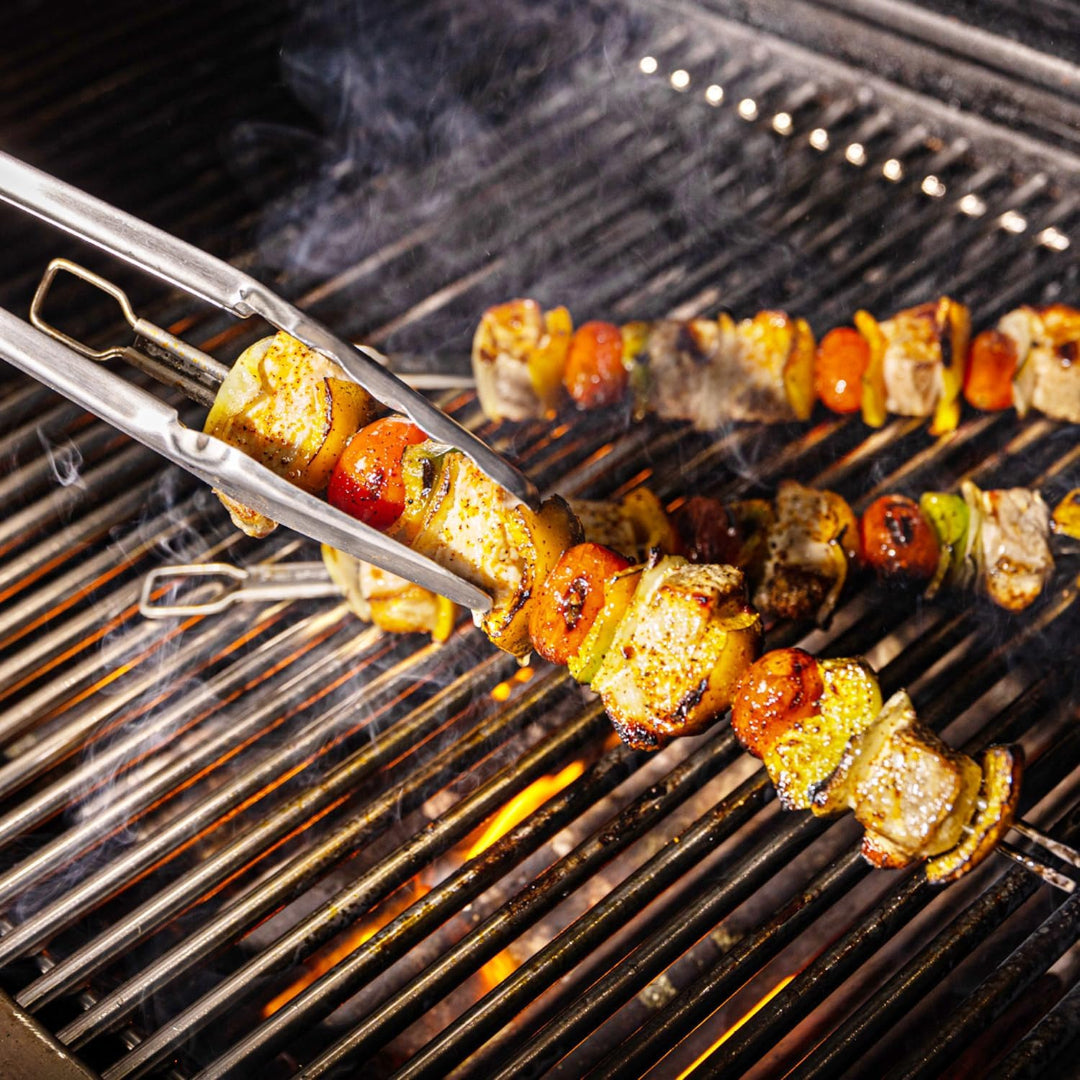 Grill, Broil King, Baron Series, grilling skewers with chicken and vegetables over lit cast iron grates