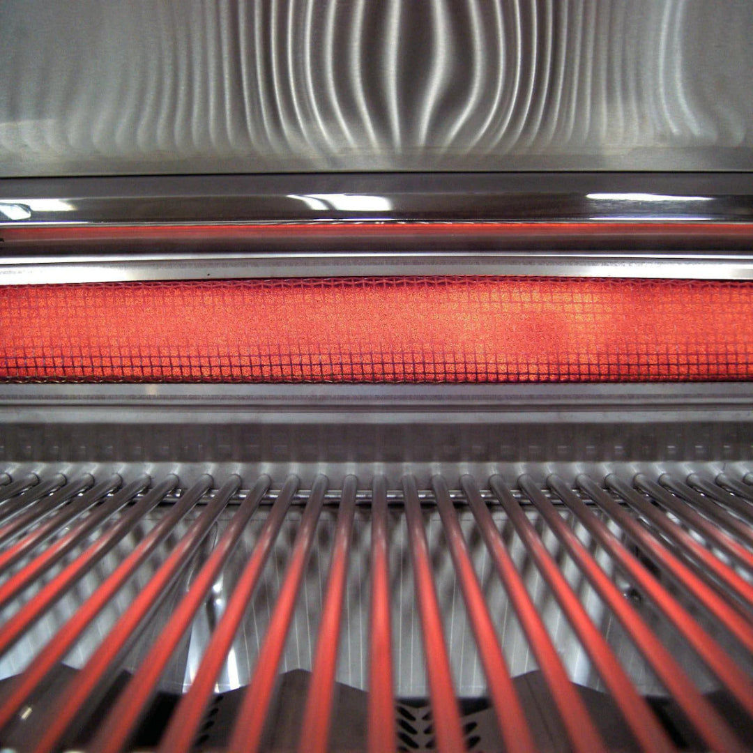 Fire Magic Close-up of glowing infrared ceramic sear burner behind stainless steel cooking grates inside outdoor propane infrared BBQ grill