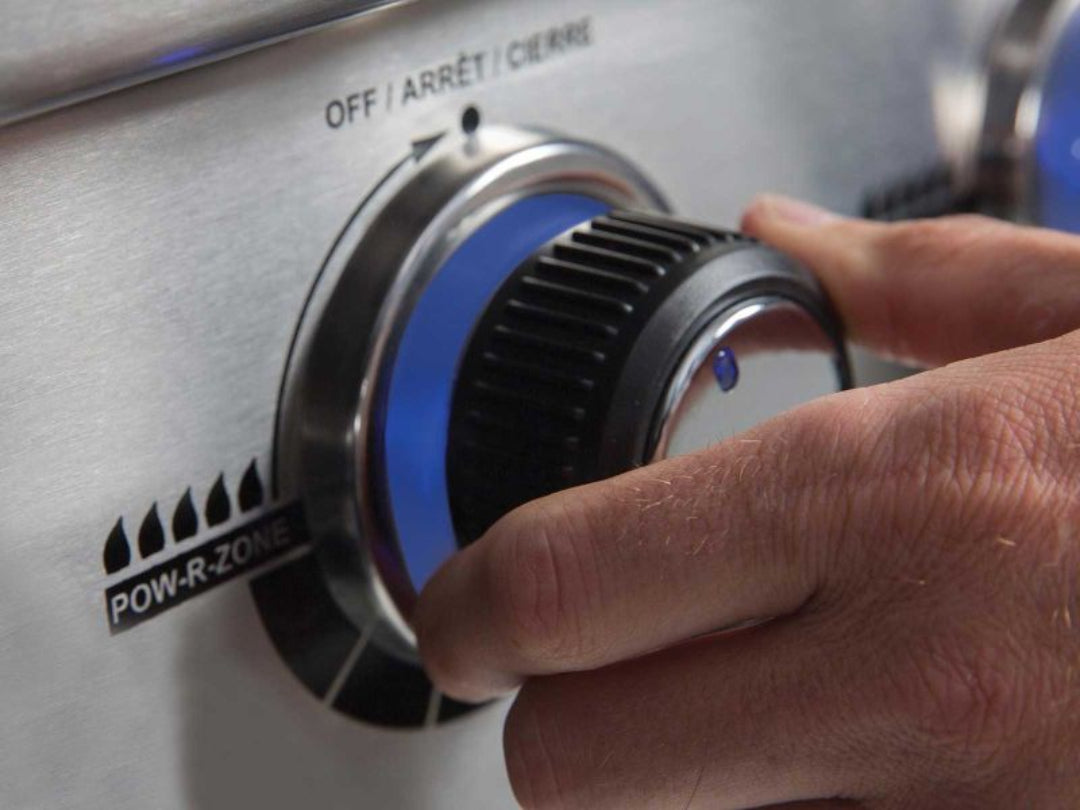 Broil King Regal grill knob with Pow-R-Zone indicator, close-up of user adjusting heat control