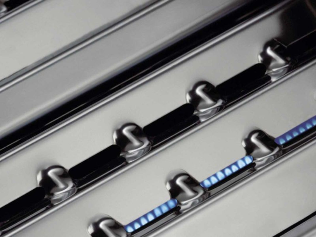 Broil King stainless steel Flav-R-Wave heat plates above blue flames for even heat and vaporization