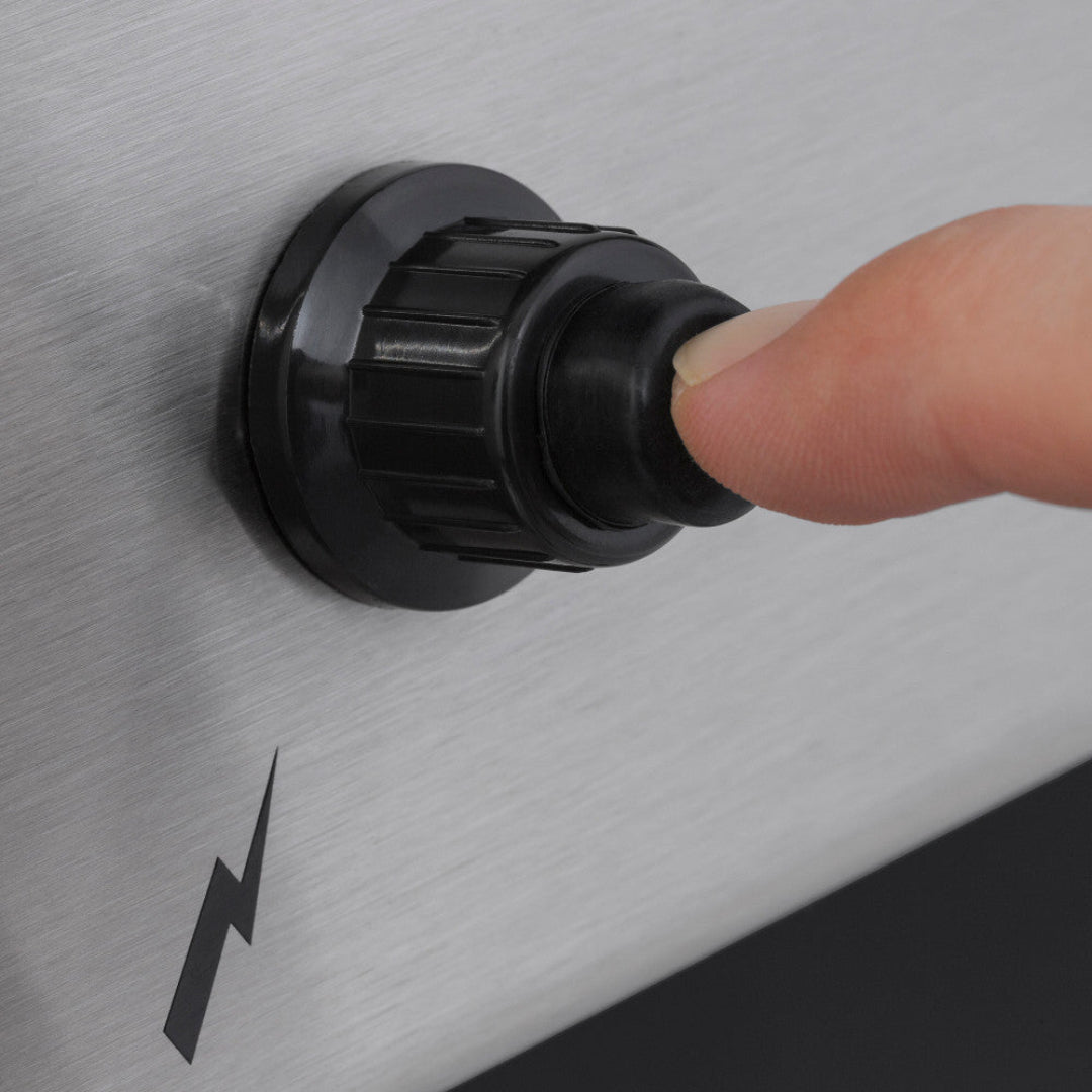 Ignition button, Broil King Signet, close-up of Sure-Lite electronic ignition being pressed for reliable start