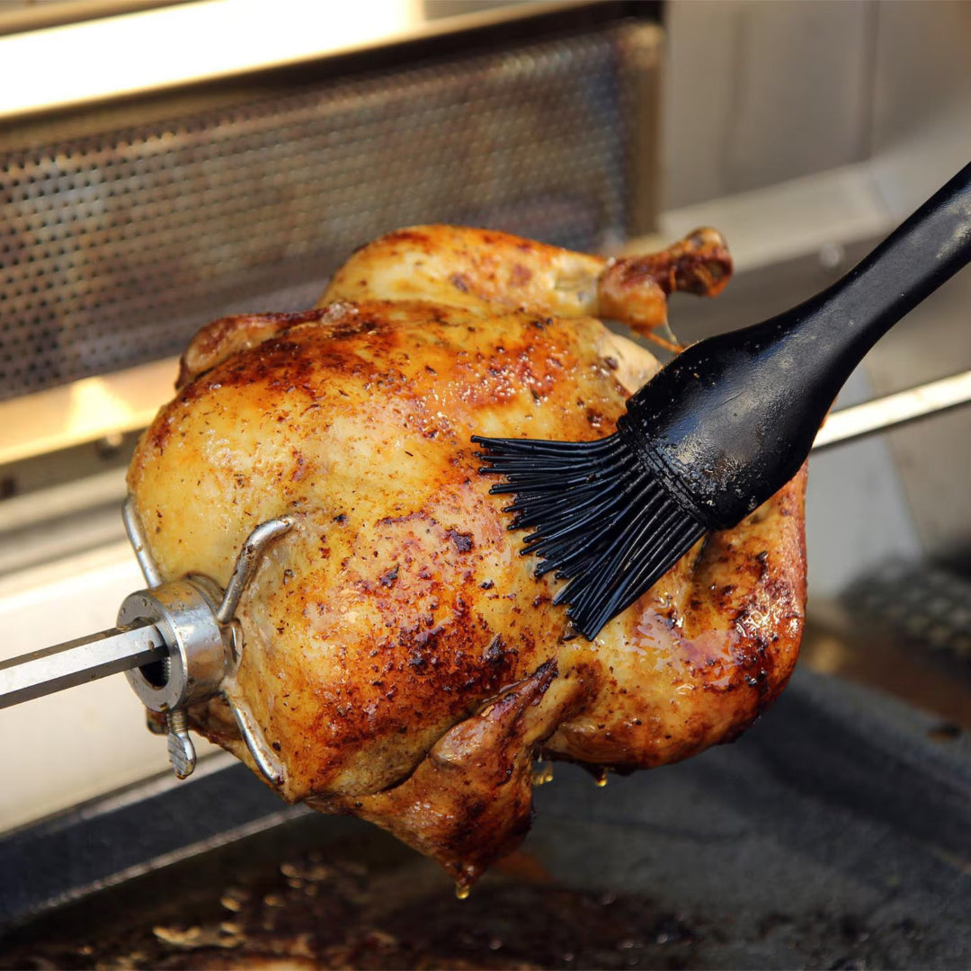 Silicone basting brush for rotisserie chicken glazing whole bird on stainless steel spit rod — Vine & Flame grill accessory