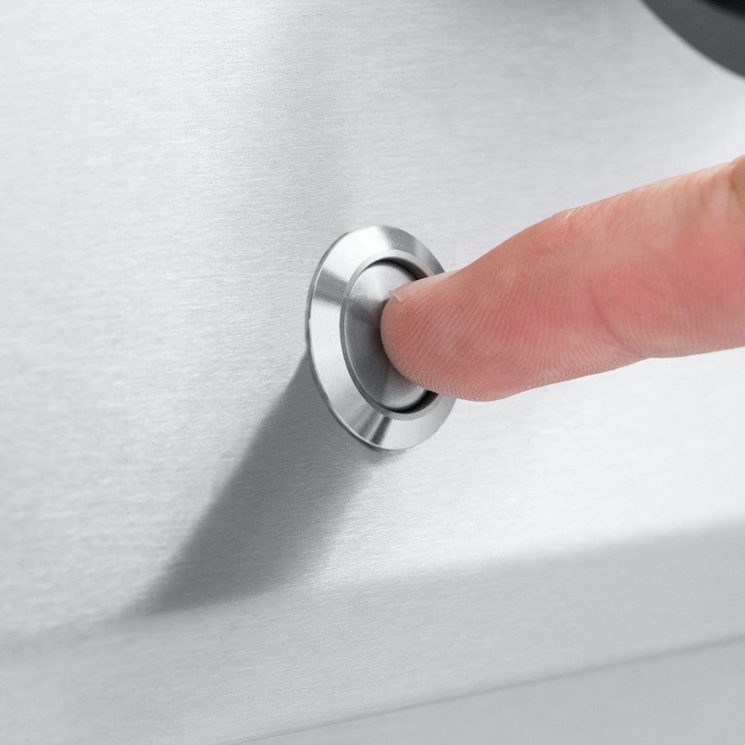 Ignition button, Broil King, Baron Series, stainless steel push starter being pressed