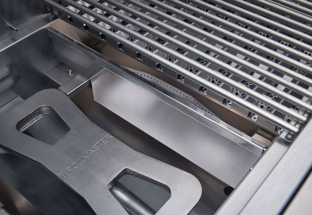 Broilmaster 42-inch 4-burner built-in stainless steel natural gas grill BSG424N5 interior close-up showing stainless steel cooking grates, Broilmaster-branded heat shield/flame tamer, burner tube and removable grease tray