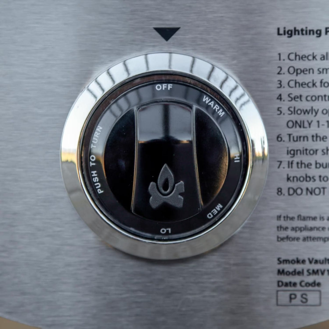 Camp Chef Smoke Vault 24-inch stainless steel gas smoker control knob close-up, push-to-turn knob with Off, Warm, Hi, Med, Lo settings