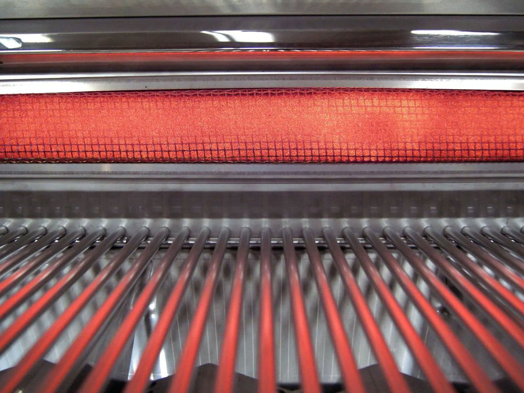E790i gas grill close-up of stainless steel cooking grates with glowing red infrared ceramic sear burner behind protective mesh — outdoor BBQ infrared burner replacement part