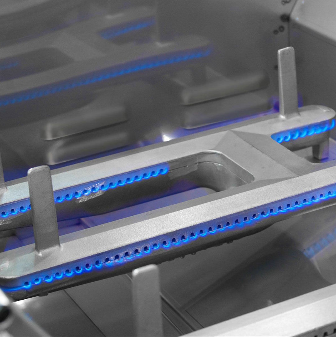 E790i cast iron linear gas burner head close-up with continuous blue flame under heavy‑duty grates — replacement gas cooktop and range burner for Vine & Flame