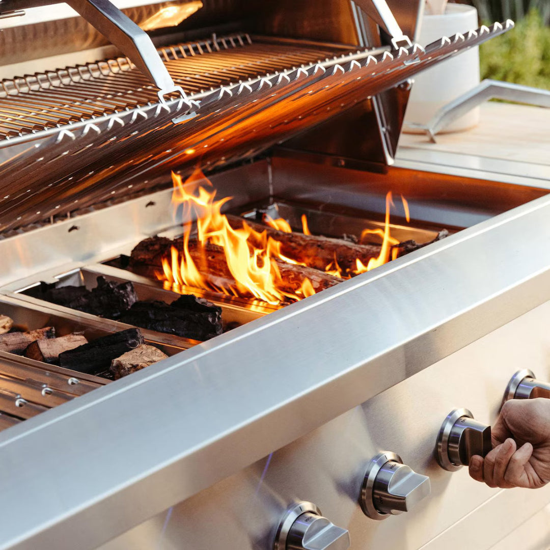 Built-in grill, American Made Grills, Encore 36-inch propane model with open lid, live wood fire trays, and stainless steel cooking grates