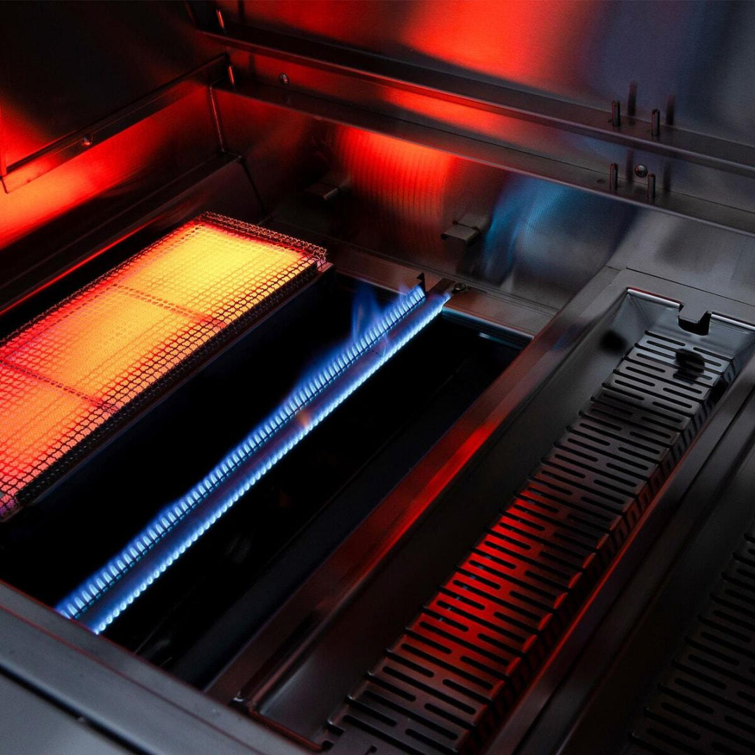 Close-up of interior infrared burner igniting inside American Made Grills Encore 54-inch hybrid grill with red and blue flame detail