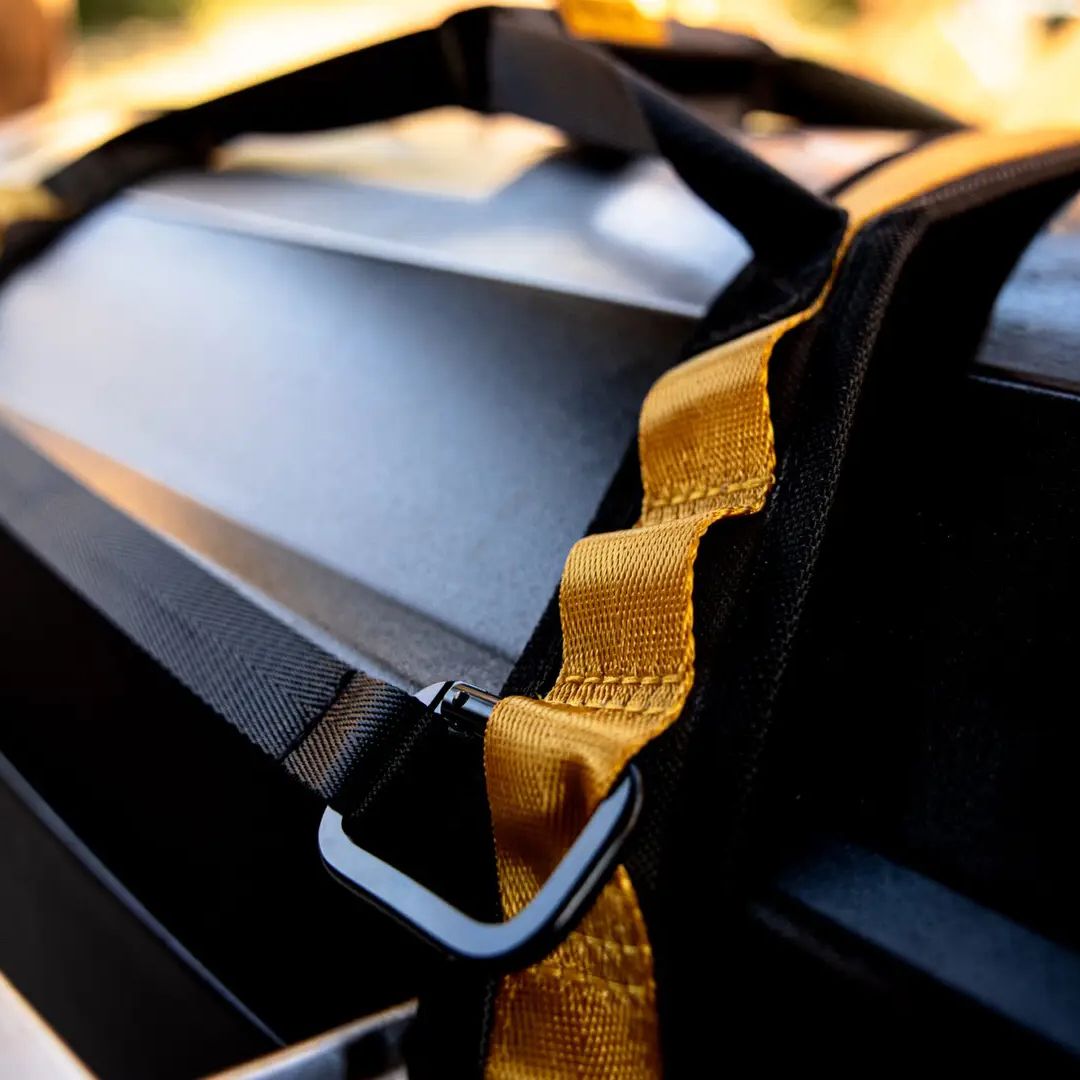 Close-up of HALO HO-3002 countertop appliance carry straps, showing black reinforced handles, gold stitched webbing loops and a metal D-ring attached to a black appliance