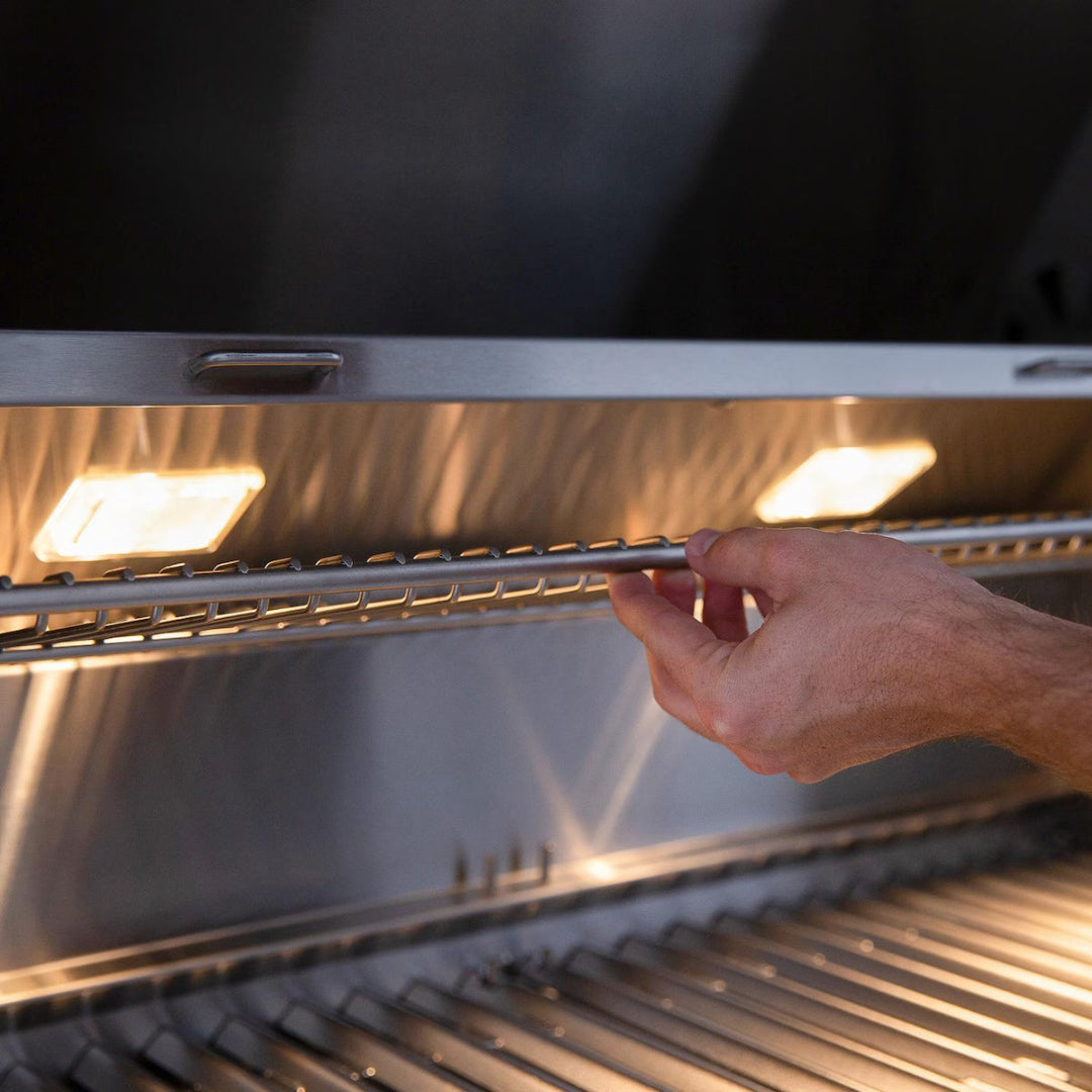 Warming rack, American Made Grills Muscle 54", hand adjusting under interior halogen lights in natural gas grill