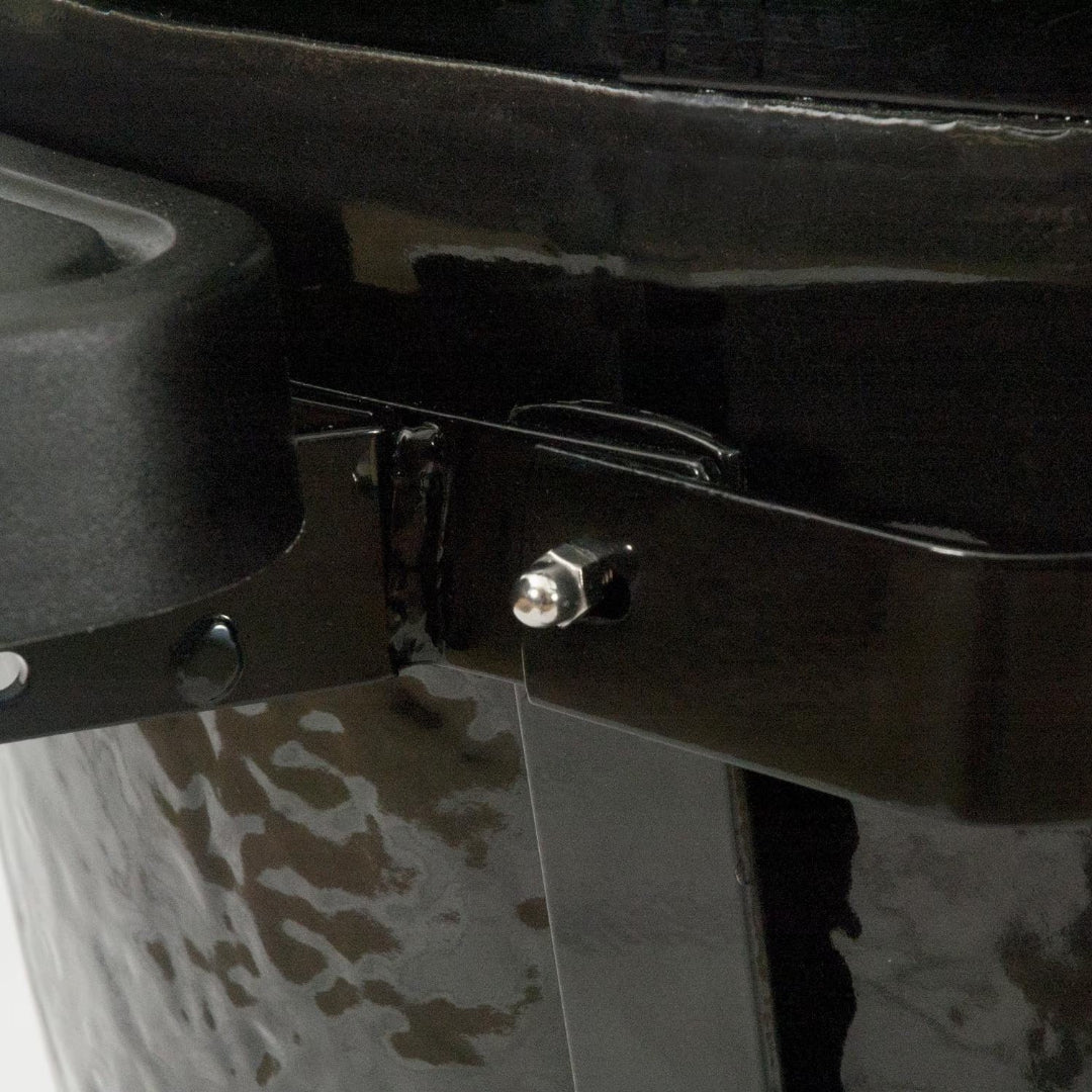 Primo XL kamado grill hinge bracket close-up showing stainless hinge pin and black hammered ceramic exterior