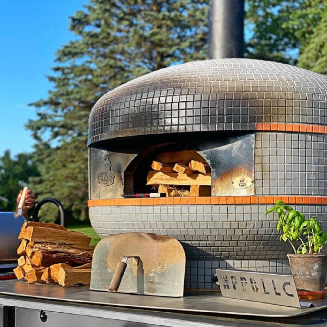 Pizza oven, WPPO, Lava Series, 28-inch wood-fired unit loaded with firewood on stainless steel base