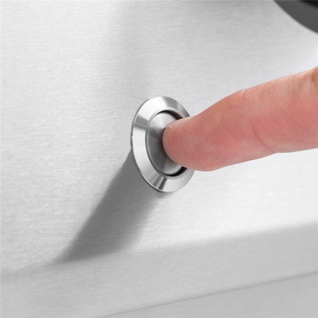 Finger pressing stainless steel push-button igniter on brushed stainless steel gas grill, replacement piezo ignition button for Vine and Flame BBQ burners