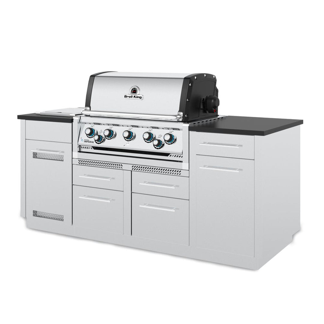 Broil King Imperial S 590i 5-burner stainless steel built-in gas grill in white modular outdoor kitchen island with black countertop and storage drawers