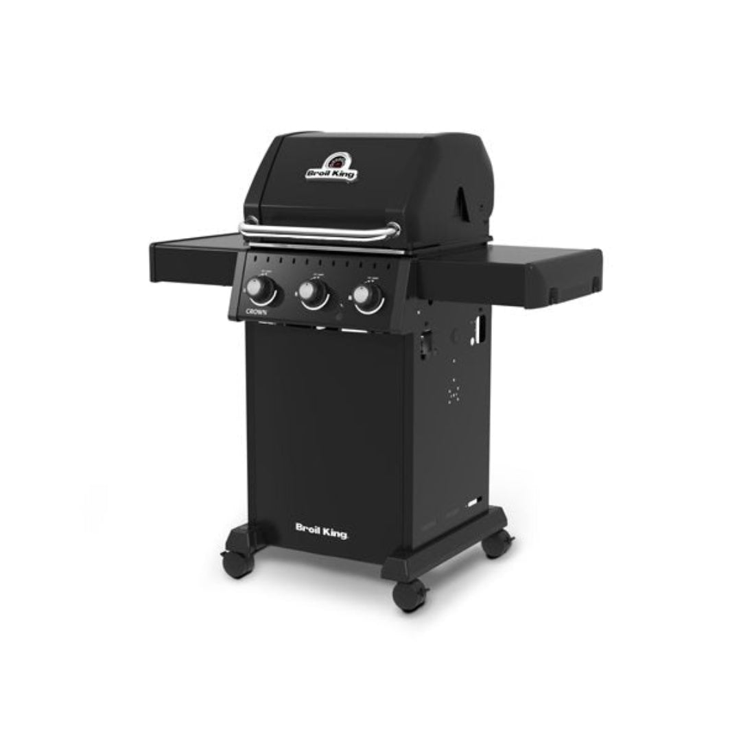 3-burner gas grill, Broil King Crown Series with closed lid, side shelves, and caster wheels, angled front view on white background.
