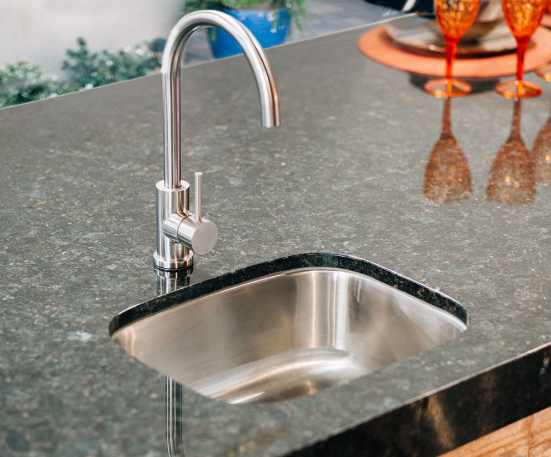 Trueflame TF-NK-19U undermount stainless steel single-bowl prep/bar sink with brushed nickel gooseneck single-handle faucet on dark granite kitchen island countertop