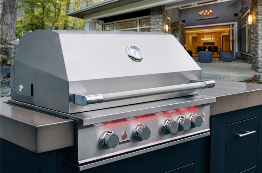 40-inch Trueflame built-in stainless steel gas grill with hood thermometer and glowing red backlit control knobs integrated into luxury outdoor kitchen island