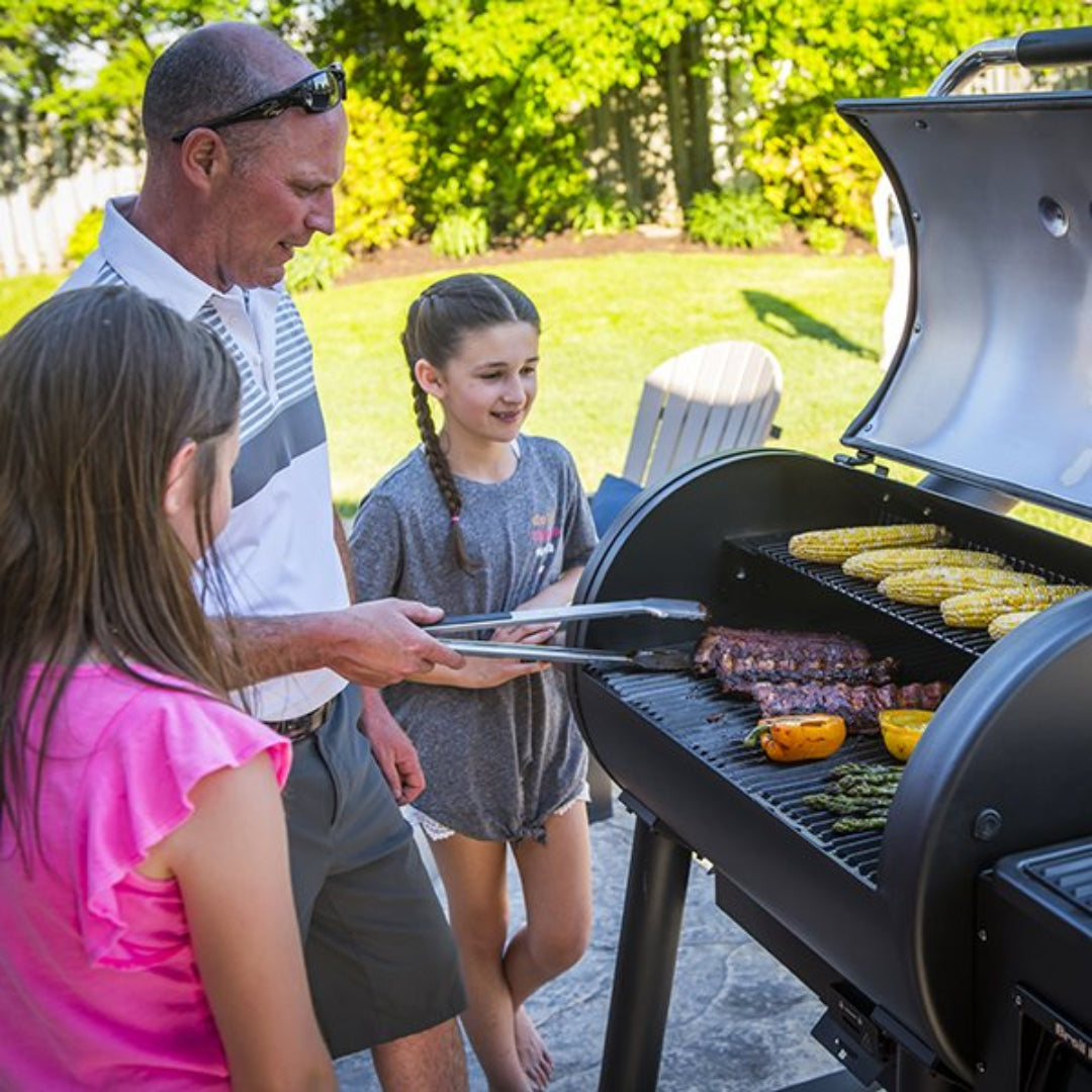 Grill, Broil King, Regal Series, family grilling outdoors with open lid and food on grates