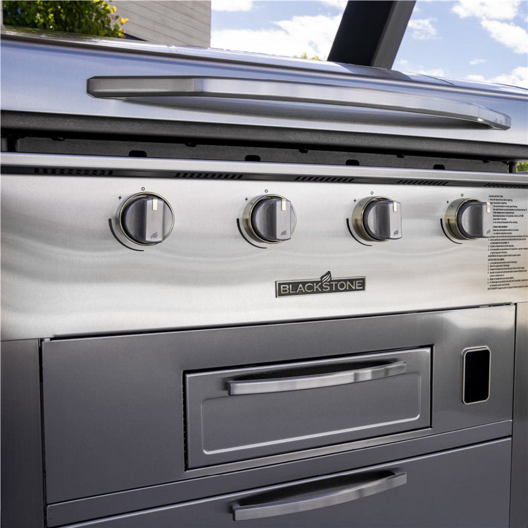 Blackstone Select 36-inch 4-burner stainless steel outdoor gas griddle and air fryer combo front panel showing control knobs, Blackstone logo, grease drawer and lower storage cabinet