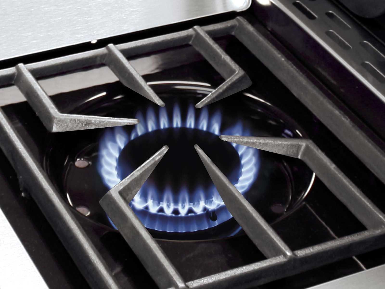 Broil King side burner with cast iron grate and blue gas flame on stainless steel grill