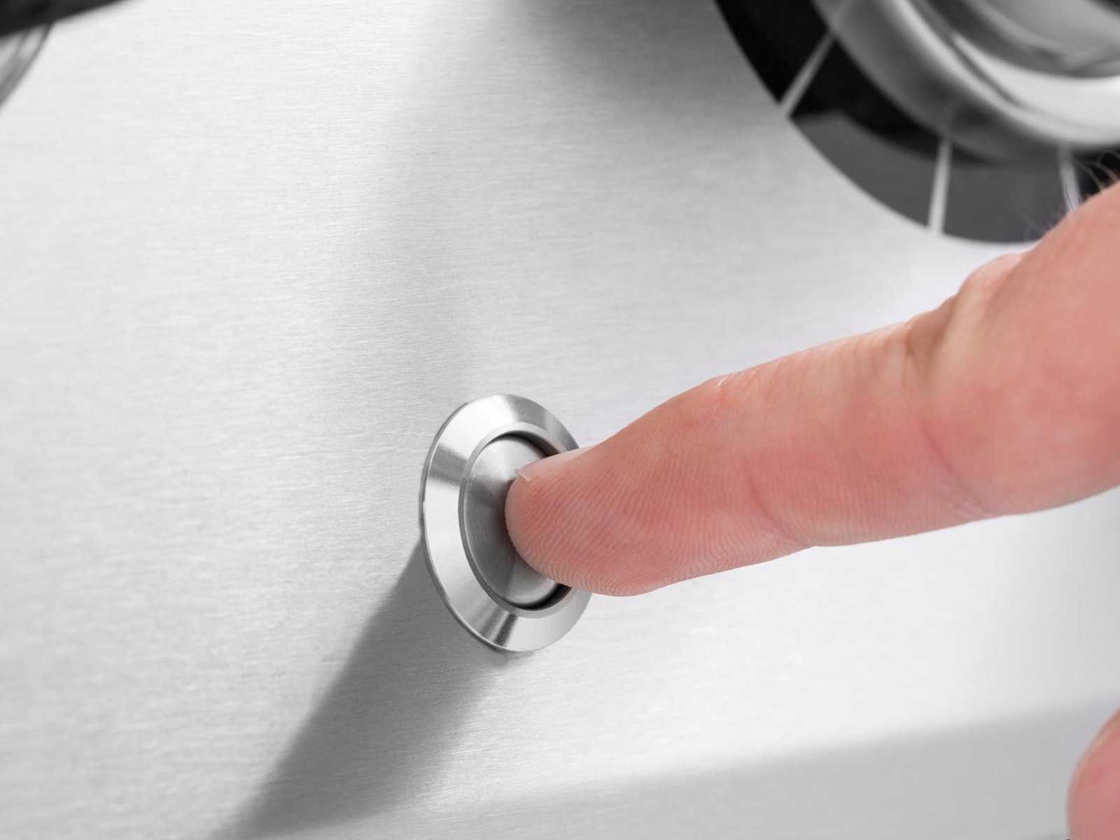 Broil King push-button ignition switch on stainless steel grill panel