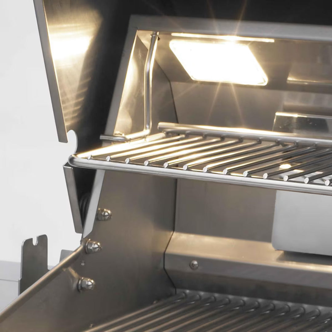 Fire magic stainless steel gas grill interior with illuminated upper warming rack, stainless steel cooking grates and built-in light