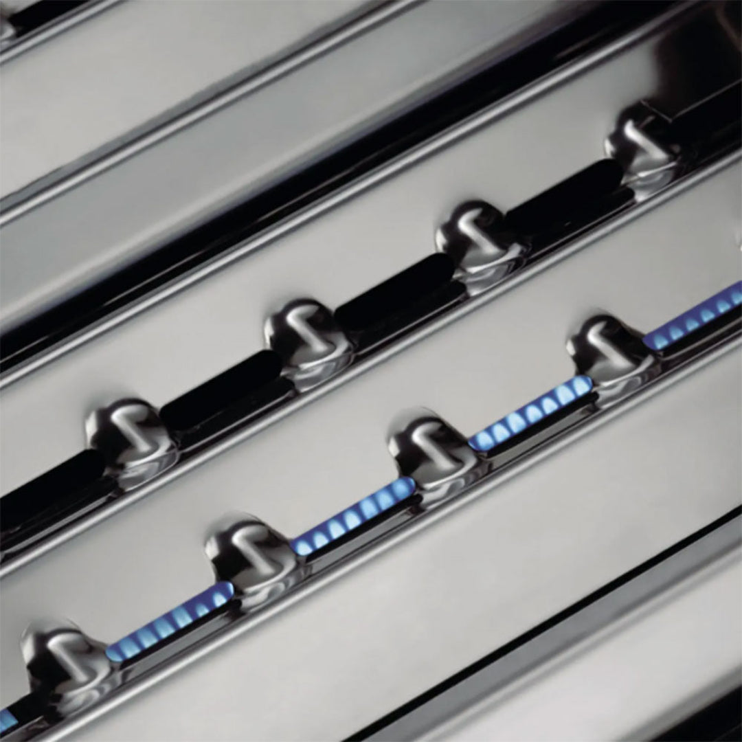 Flame tamers, Broil King, Baron Series, stainless steel with blue gas flames across burner ports