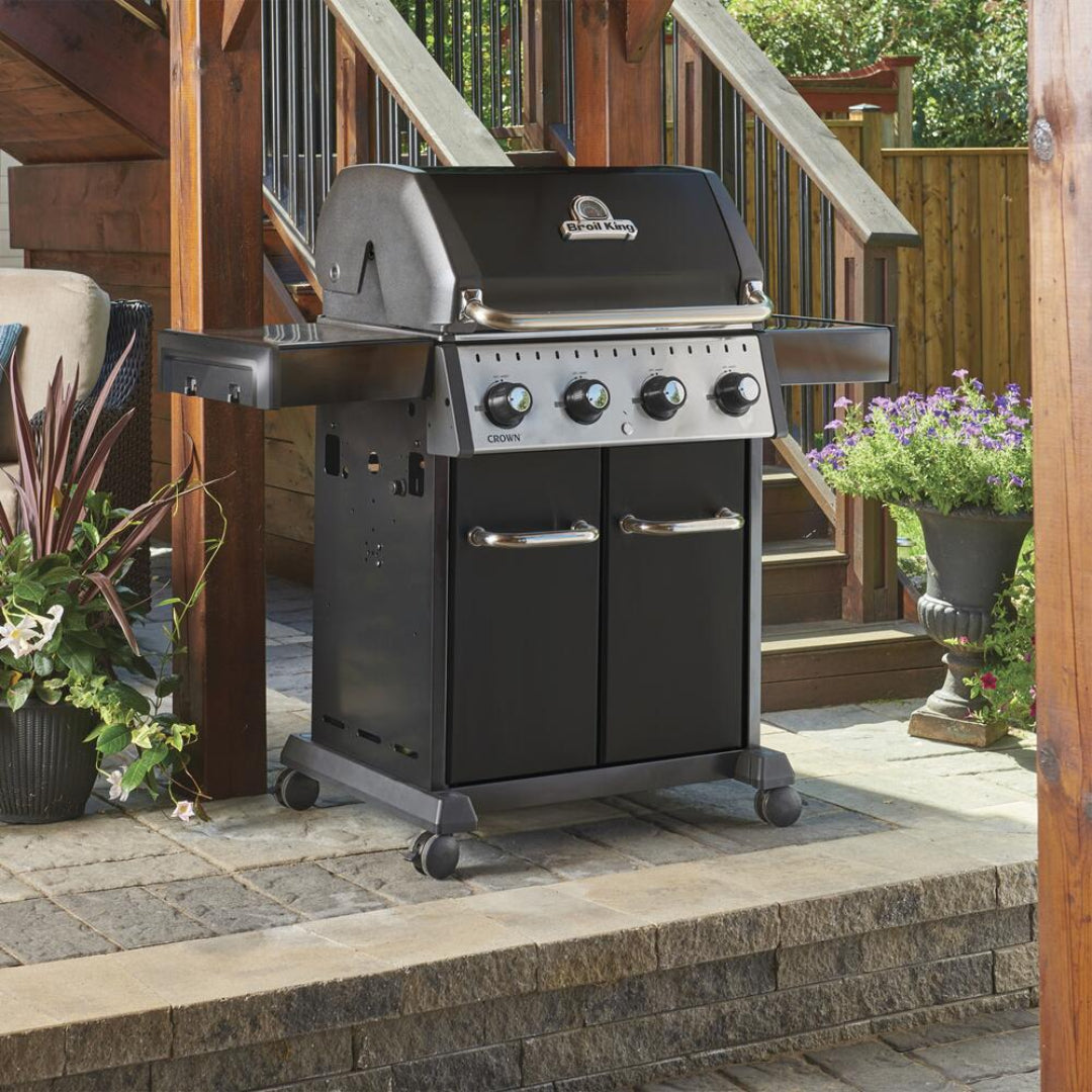 Freestanding grill, Broil King, Crown Series, black 4-burner propane gas grill on patio