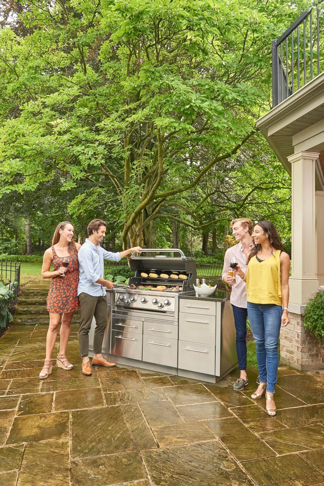 Freestanding grill, Broil King, Imperial series, 5-burner with rotisserie and side burner in outdoor patio setting.