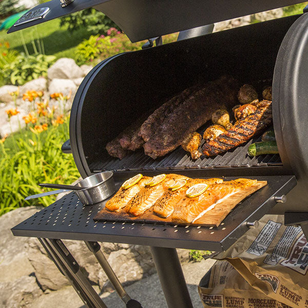Side shelf with food, Broil King, Smoke Series, expanded front shelf with salmon, ribs, and grilling tools for convenient prep