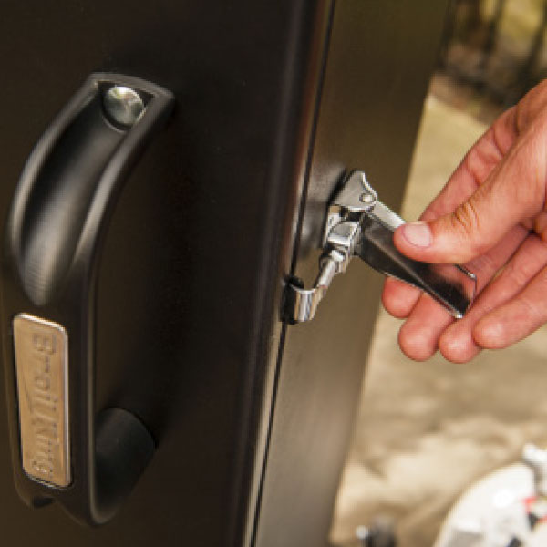 Door latch mechanism, Broil King Smoke series vertical smoker, close-up showing handle and secure locking system
