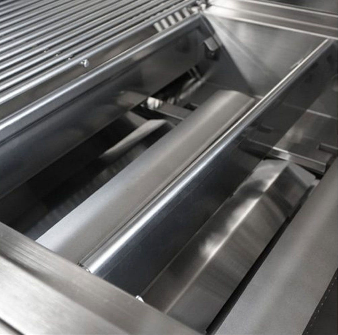Broilmaster B-Series Basic Edition BSB253NLP 3-burner 25-inch propane gas grill interior close-up showing stainless steel flame tamers (heat plates) and cooking grates