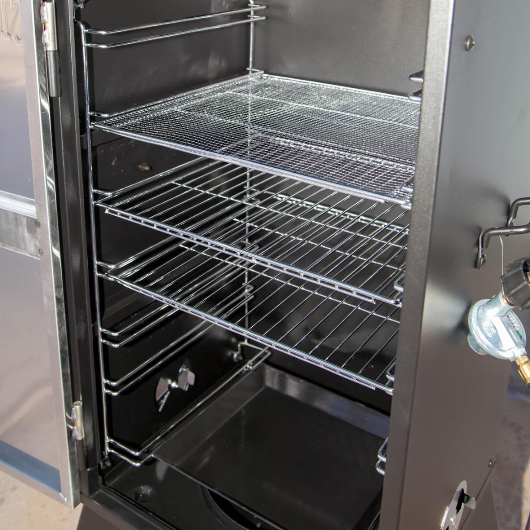 Camp Chef 24-inch vertical propane smoker interior with chrome adjustable cooking racks, wire mesh shelf, removable drip pan and propane regulator