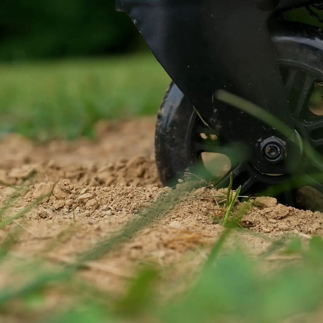 Close-up of HALO Countertop Cart (HO-1006-XNA) black swivel caster wheel rolling over dry dirt and grass