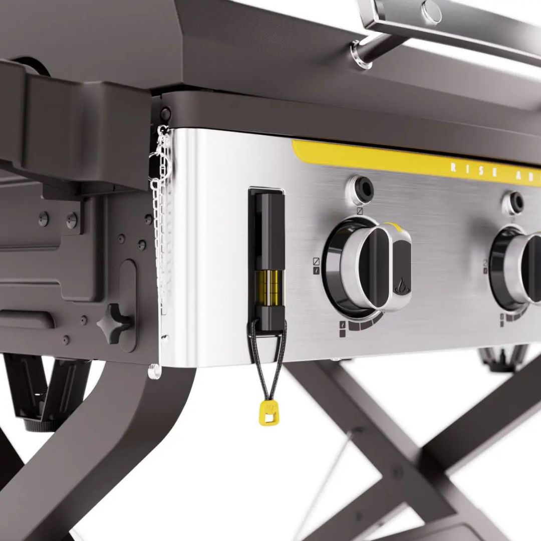 HALO Elite 3B gas griddle HZ-1002-XNA close-up of stainless steel control panel with burner knobs, integrated bubble level, yellow accent strip, ignition pull cord and folding X-frame legs