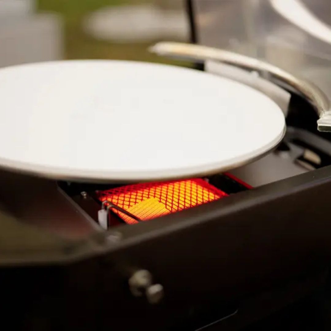 HALO Versa 16 outdoor gas pizza oven close-up of 16-inch rotating cordierite stone above glowing infrared burner