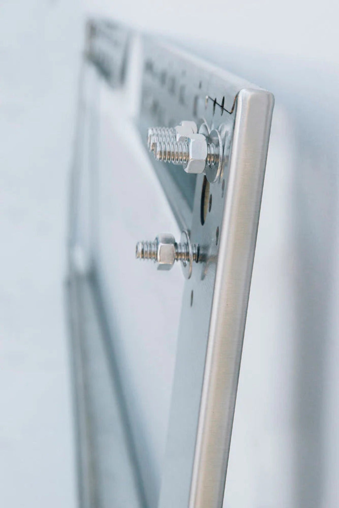 Trueflame TF-VH48-2-SPT 48-inch stainless steel mounting bracket for linear gas fire pit burner — close-up side view showing hex bolts, nuts and washers