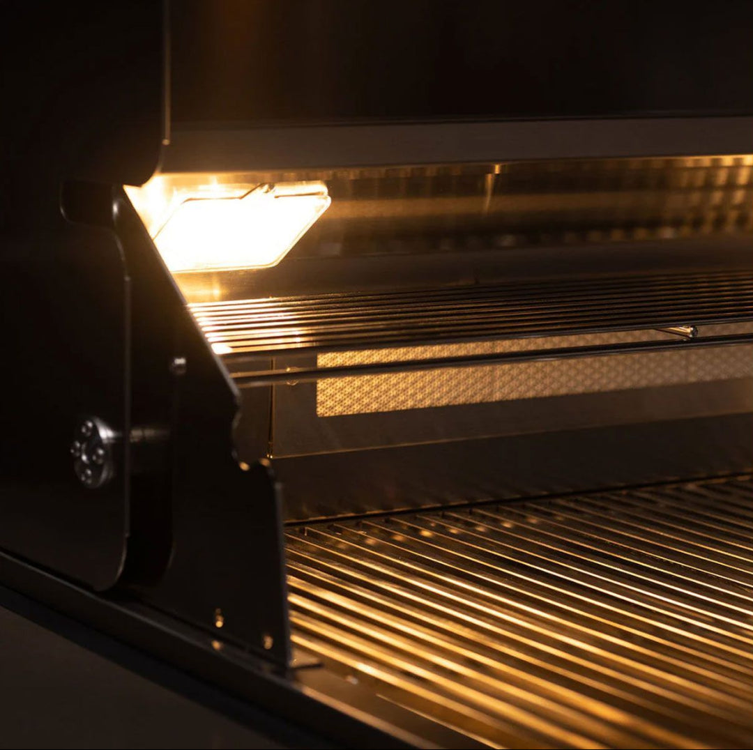 TrueFlame 32-inch 4-burner built-in natural gas grill TF32-NG interior close-up showing stainless steel cooking grates, upper warming rack and integrated hood light