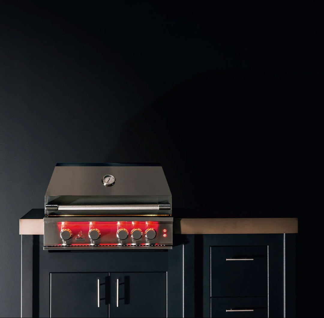 TrueFlame 32-inch 4-burner built-in natural gas grill TF32-NG3 stainless steel hood with thermometer and red LED illuminated control knobs installed in black outdoor kitchen cabinet