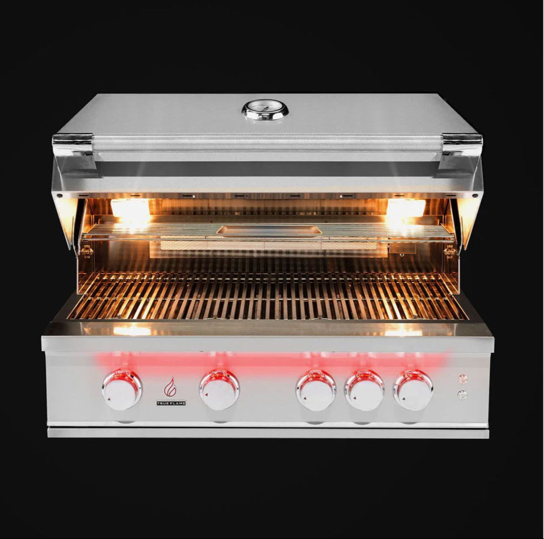 TrueFlame TF32-NG5 32-inch 4-burner stainless steel built-in natural gas grill for outdoor kitchen, open hood showing interior lights, warming rack and illuminated control knobs