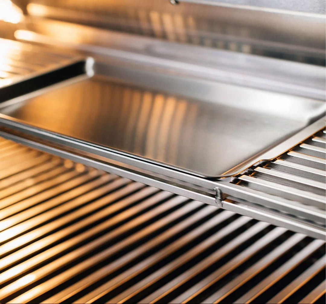 Close-up of TrueFlame TF Series 25-inch built-in 3-burner natural gas grill TF25-NG5 interior showing stainless steel cooking grates, upper warming rack and removable stainless steel griddle