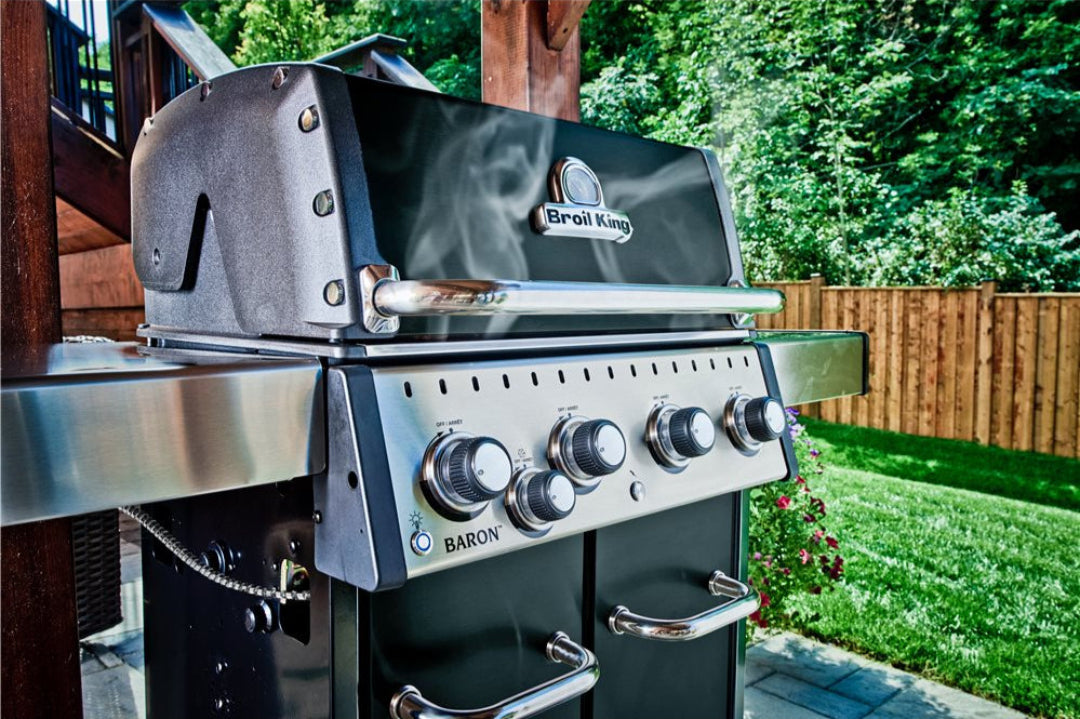 Freestanding grill, Broil King, Baron Series, 4-burner propane grill outdoors with stainless steel shelves and smoking hood
