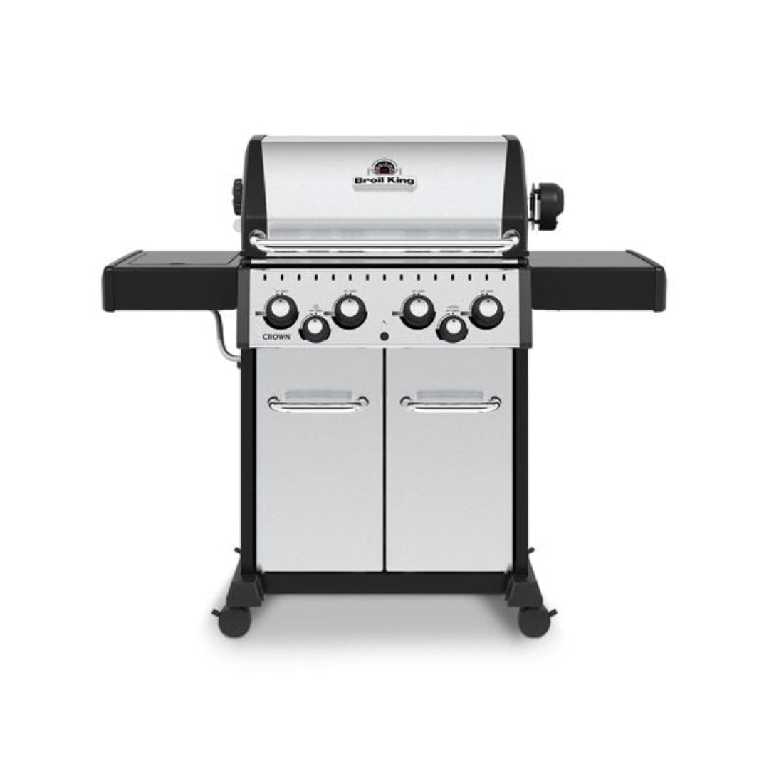 Broil King Crown freestanding gas grill with four knobs, dual-door cabinet, and fold-down side shelves