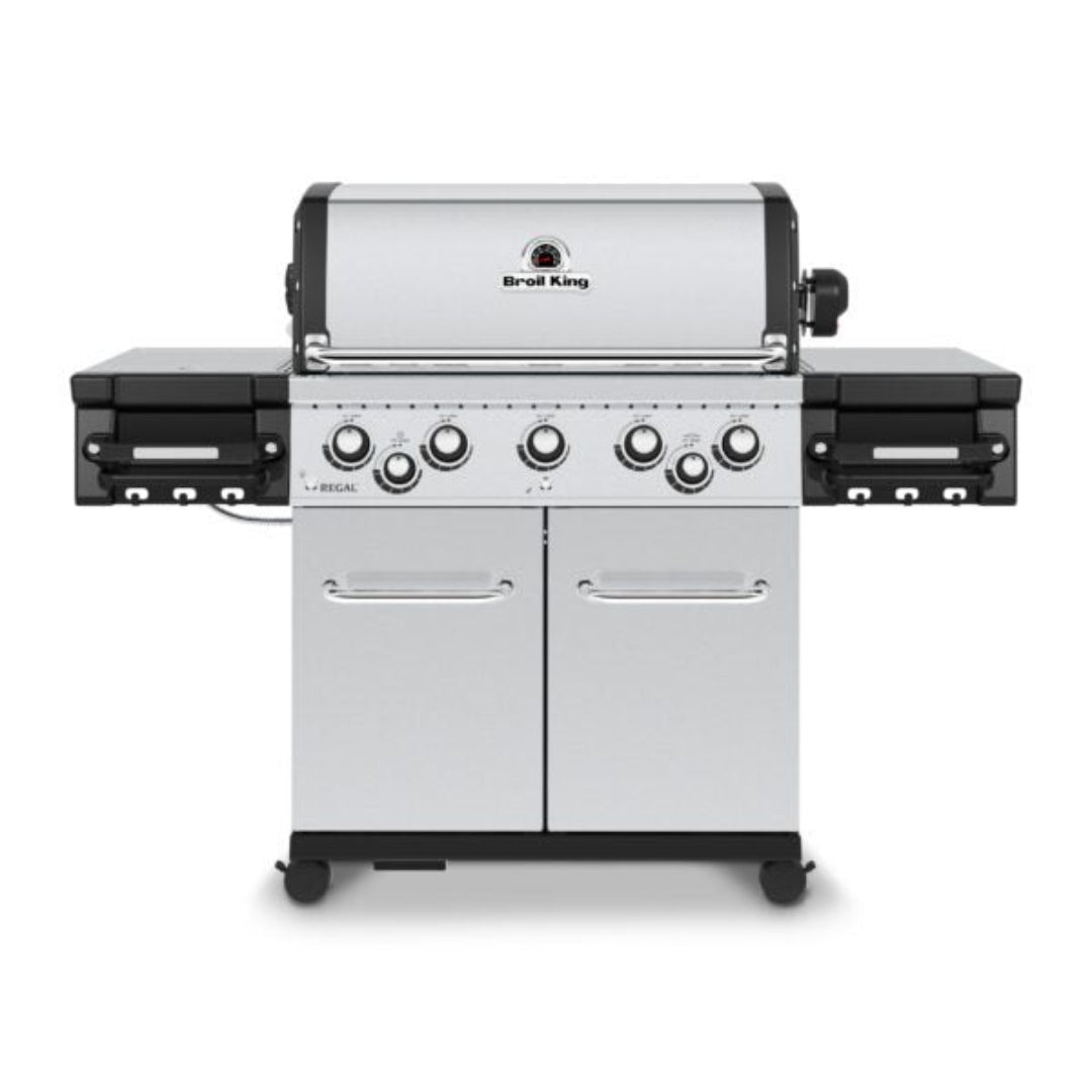 Broil King Regal S 590 Pro stainless steel 5-burner gas grill with side shelves, integrated side burners, double-door storage cabinet and caster wheels — front view