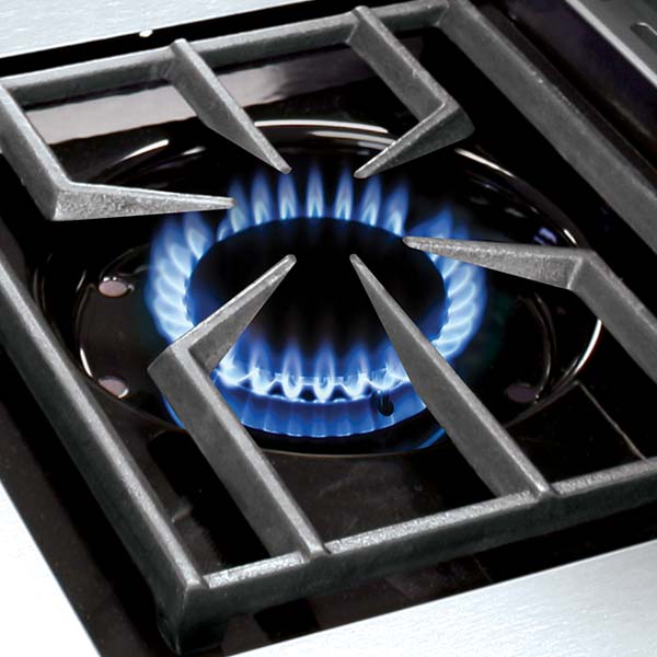Vine and Flame heavy-duty stainless steel gas cooktop burner with cast-iron grate and blue flame close-up